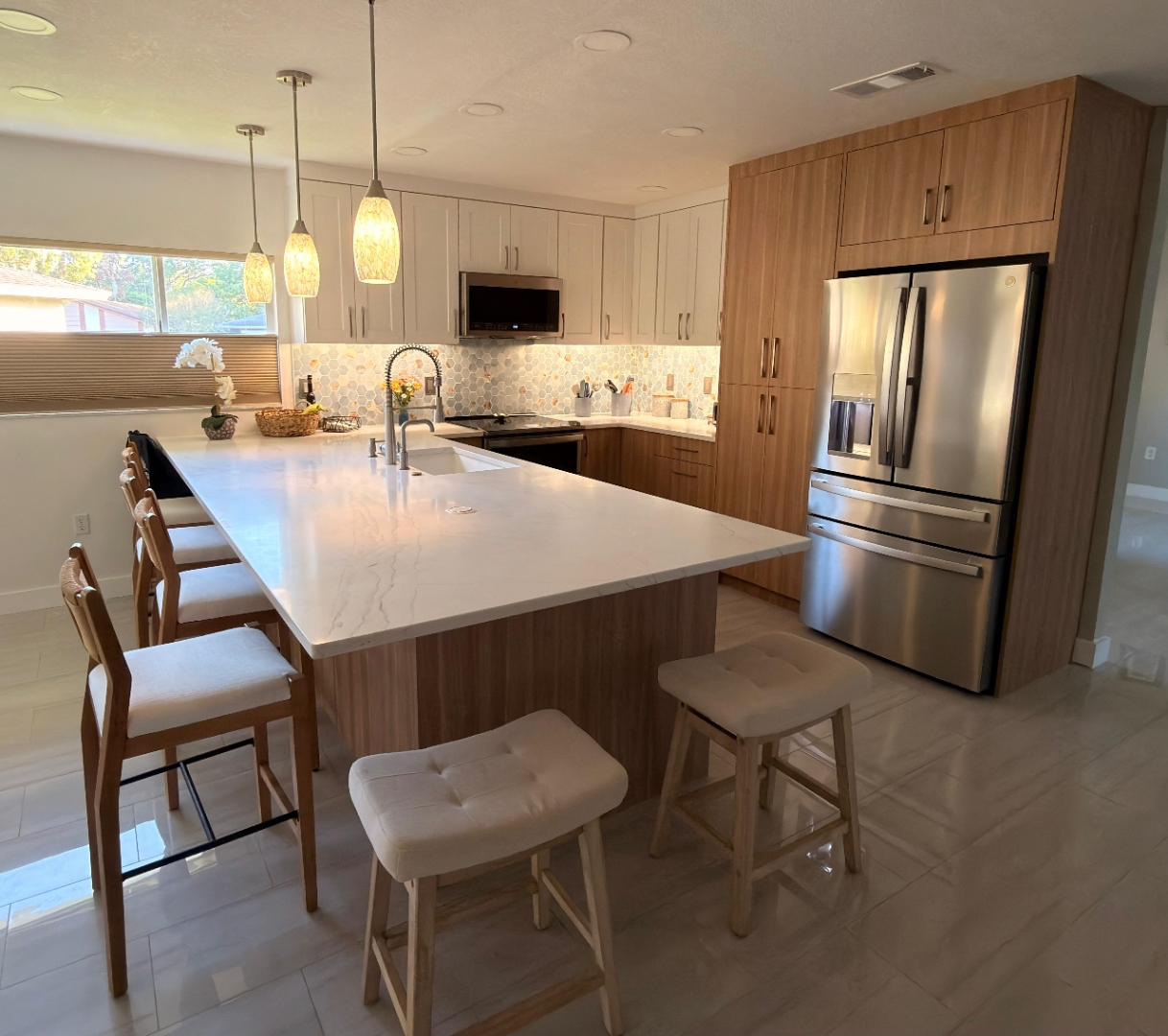 Contemporary kitchen in Hudson Florida, Parona walnut tall cabinets, flush integrated Sub-Zero appliances, honed Calacatta marble waterfall island